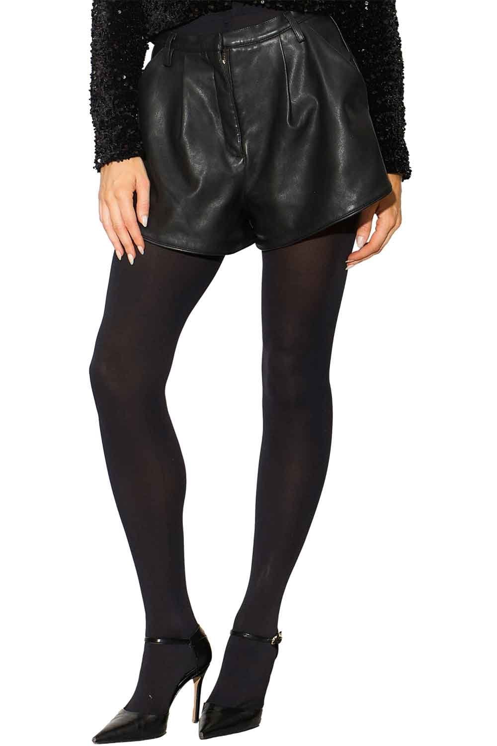 Model wearing black leather shorts and black opaque tights on a white background