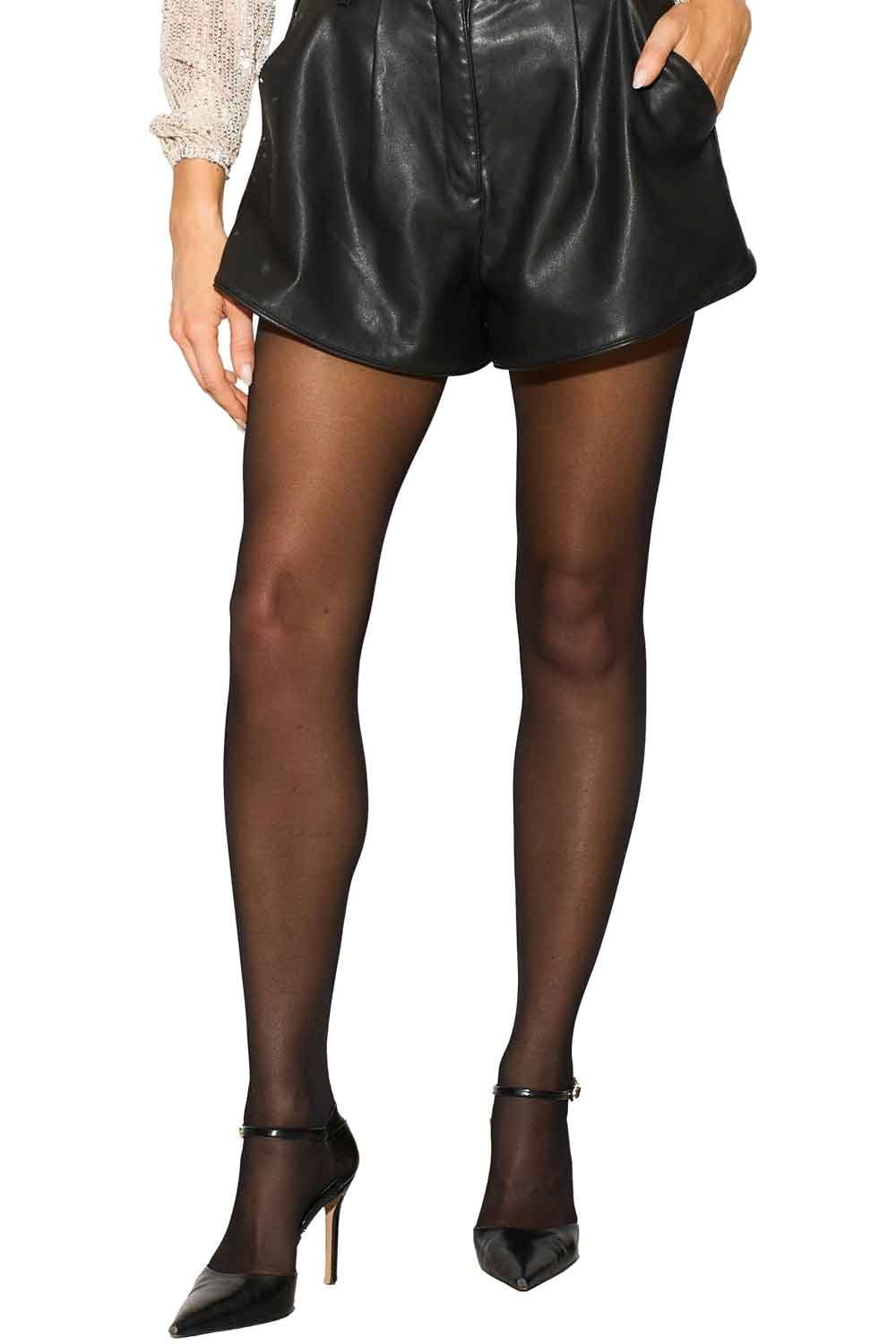 Model wearing black leather shorts and black sheer tights  tights on a white background