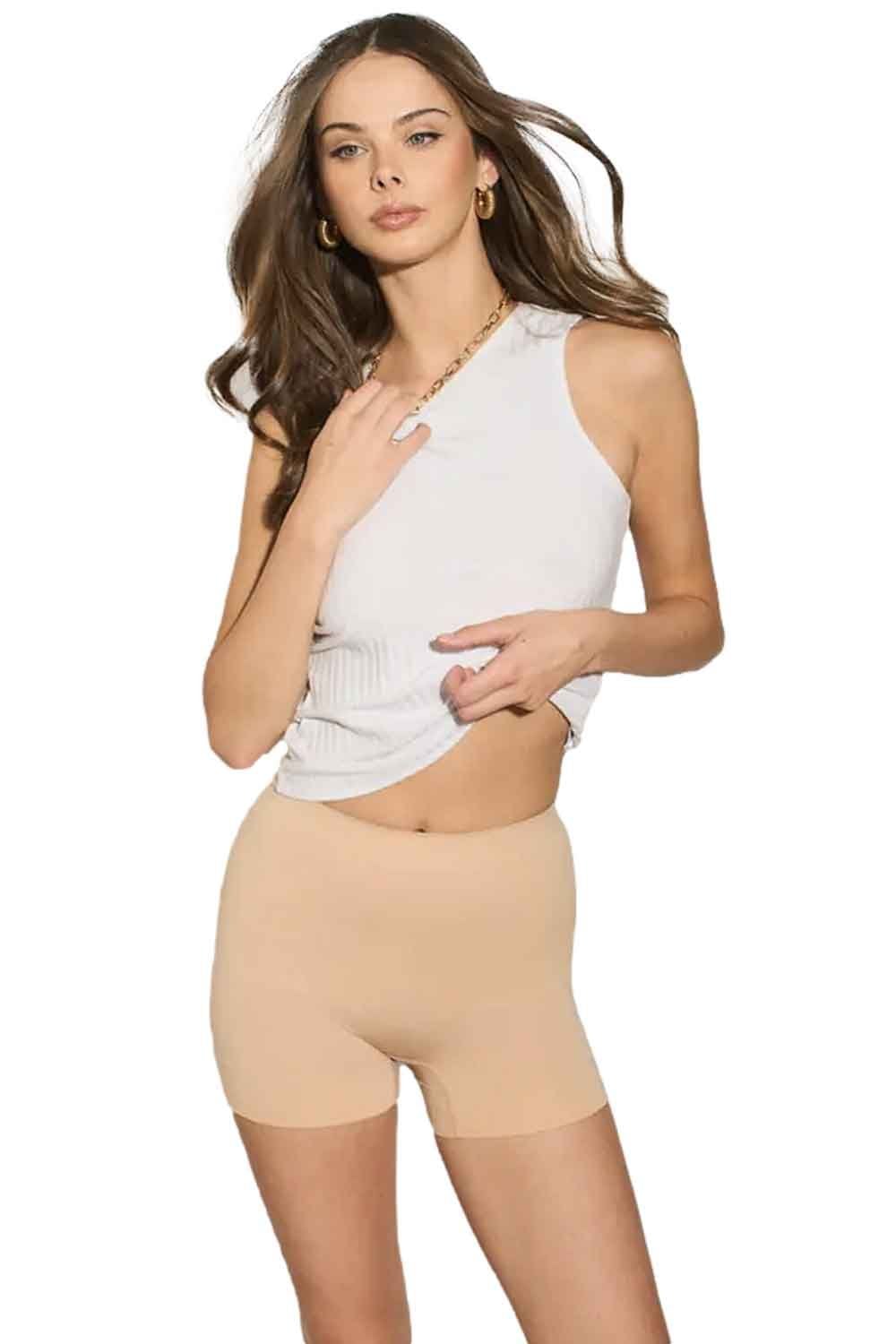 Model wearing nude coloured shapewear shorts on a white background