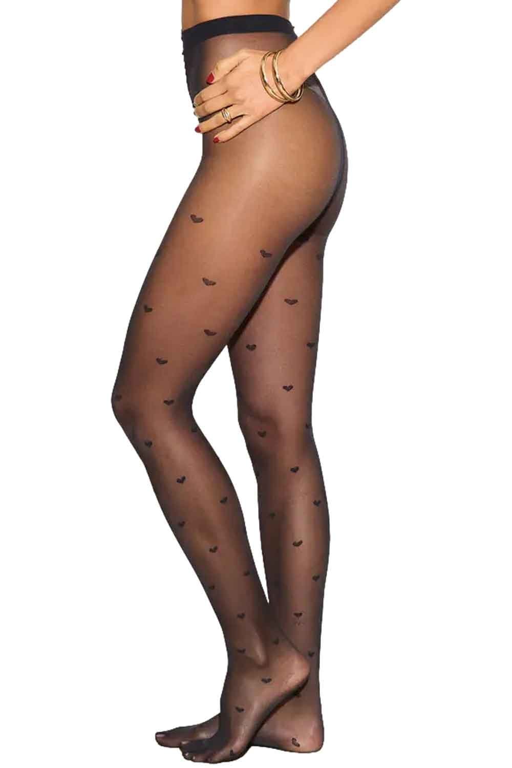 Sheer black tights with heart patterns worn by a model on a white background