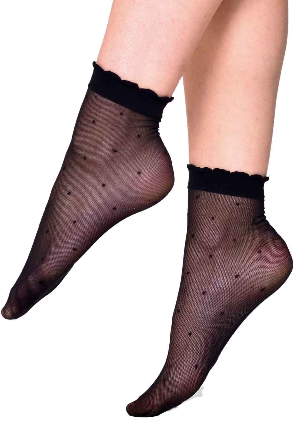 Black sheered socks with dot pattern worn by a person on a white background