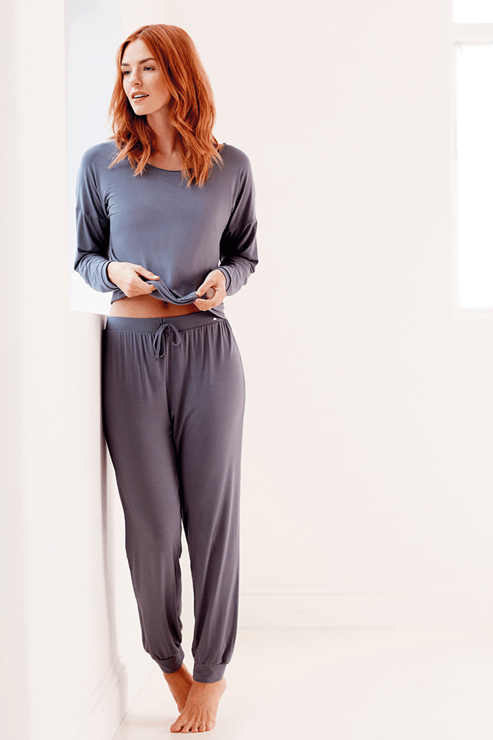 Woman wearing a lace slouch top against a white background