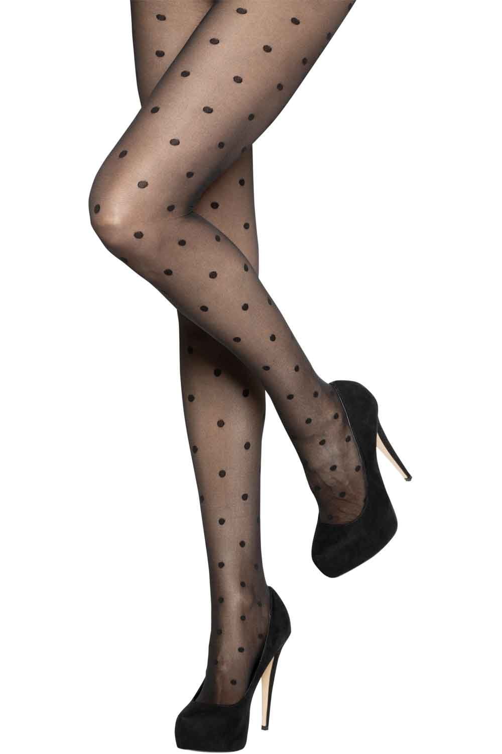 Black polka dot tights worn with black high heels on a white background