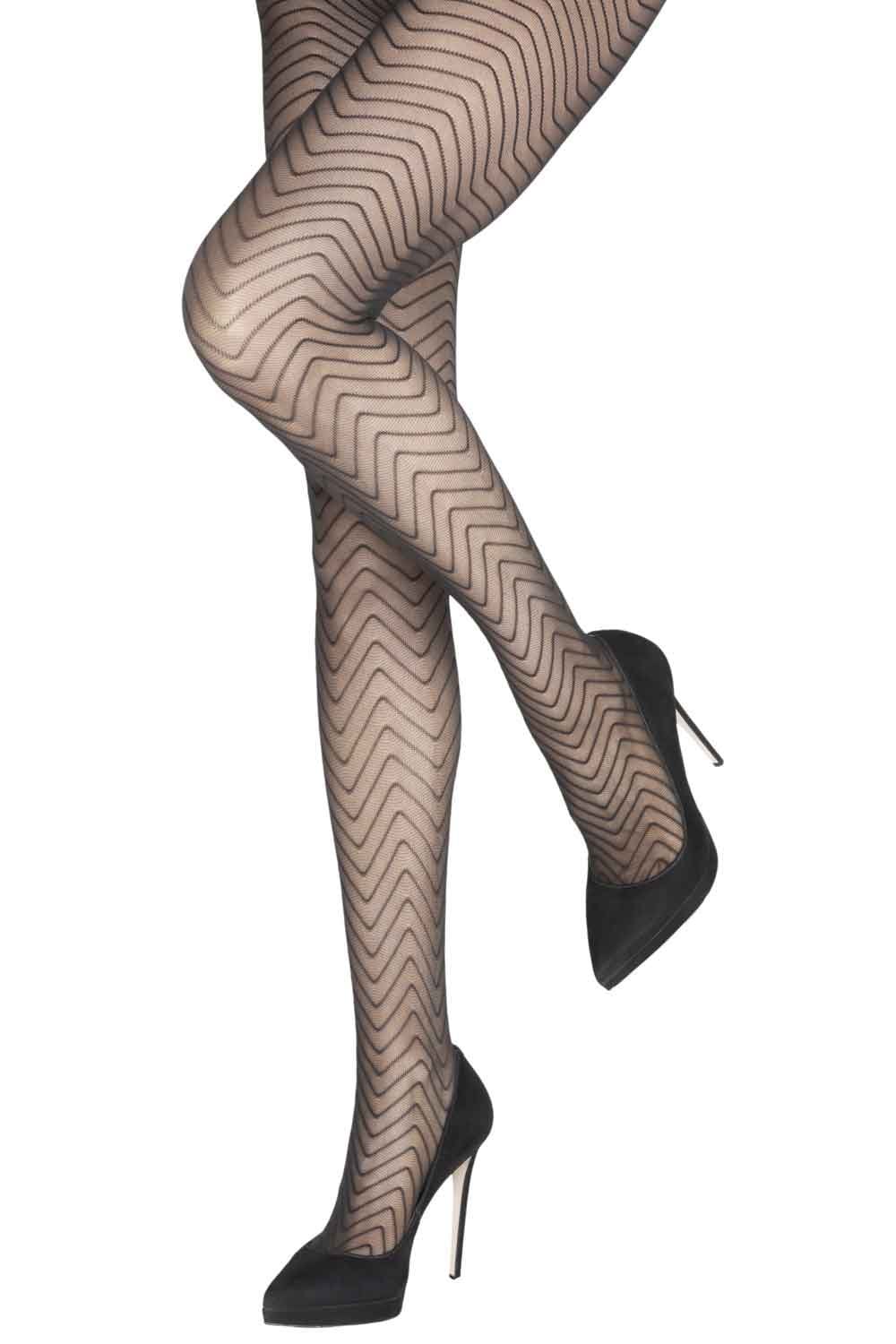 Black chevron patterned tights worn with black high heels on a white background