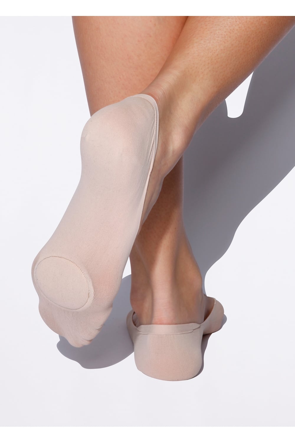 Natural coloured socks worn by a person on a white background