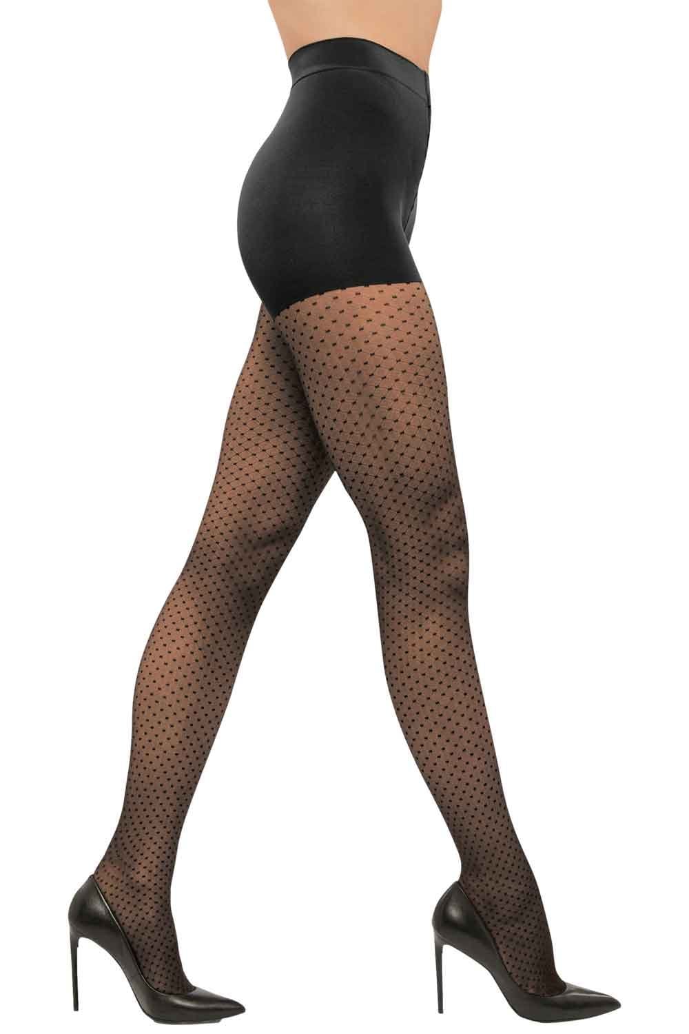 Black dot patterned  tights worn with high heels on a white background