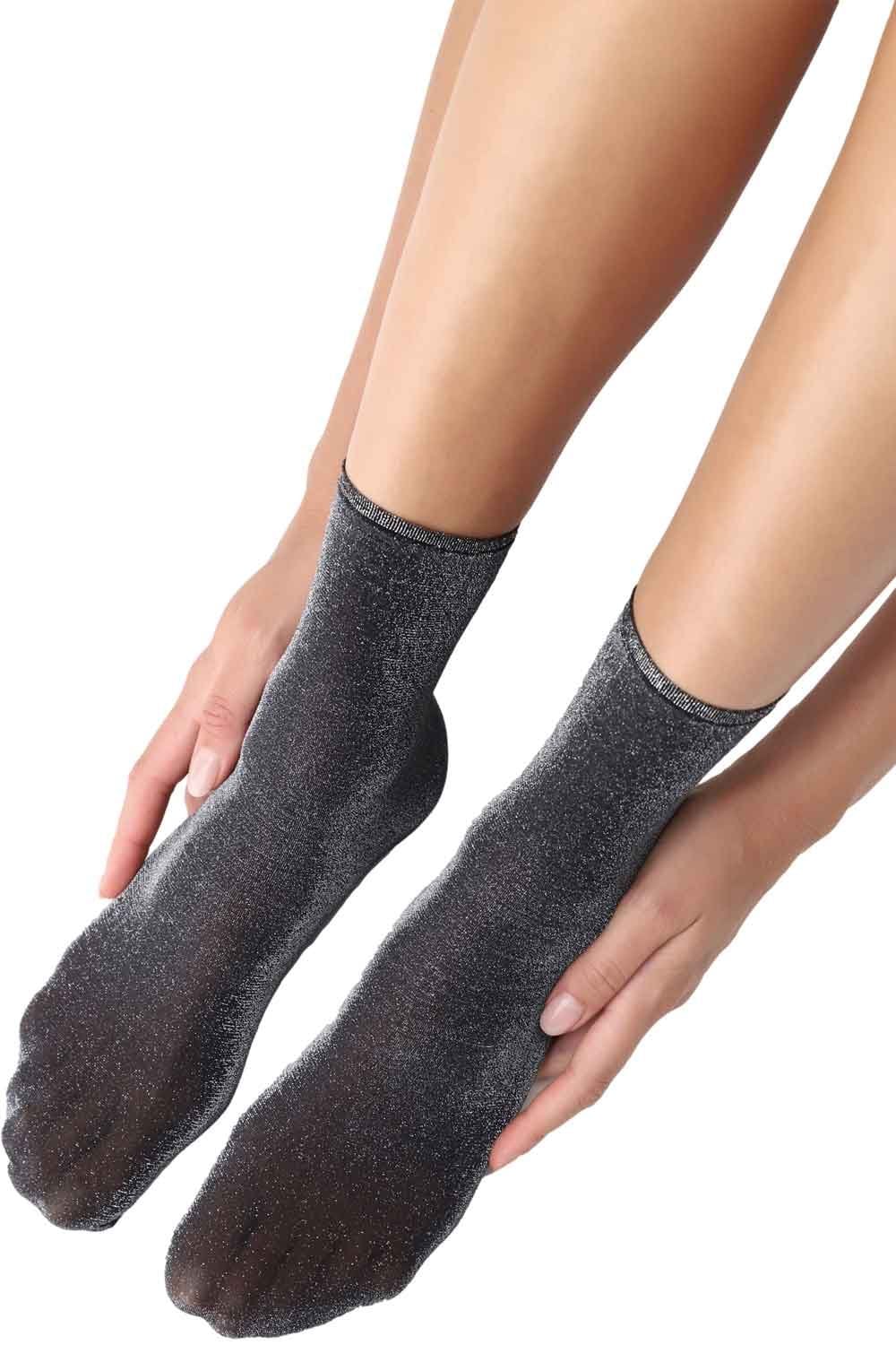 Silver sparkly socks being worn on a white background