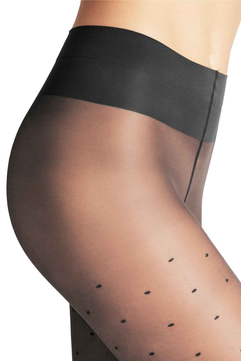 Black sheer tights with dot pattern worn by a person on a white background