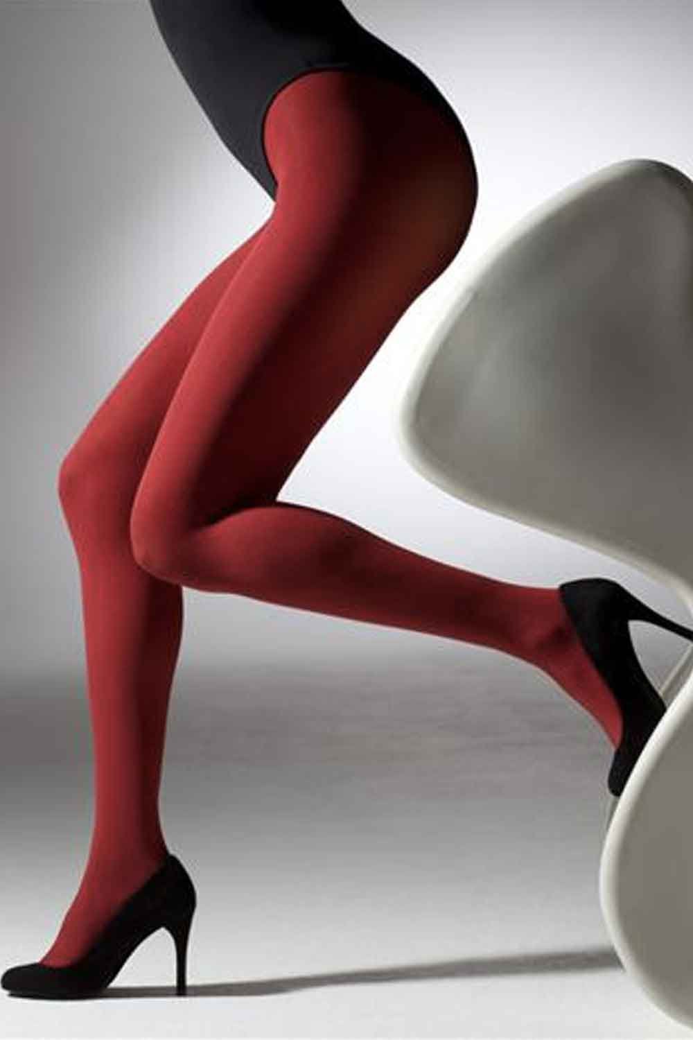 Red tights worn by a person sitting on a white chair against a gray background