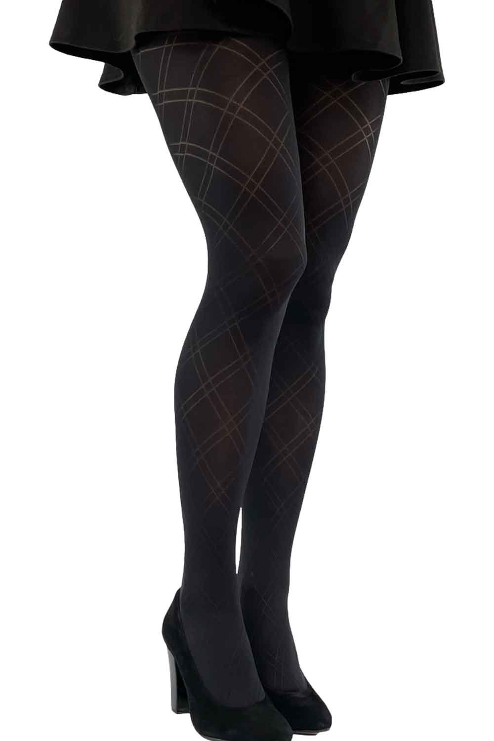 Black diamond patterned tights worn with a black skirt and shoes on a white background