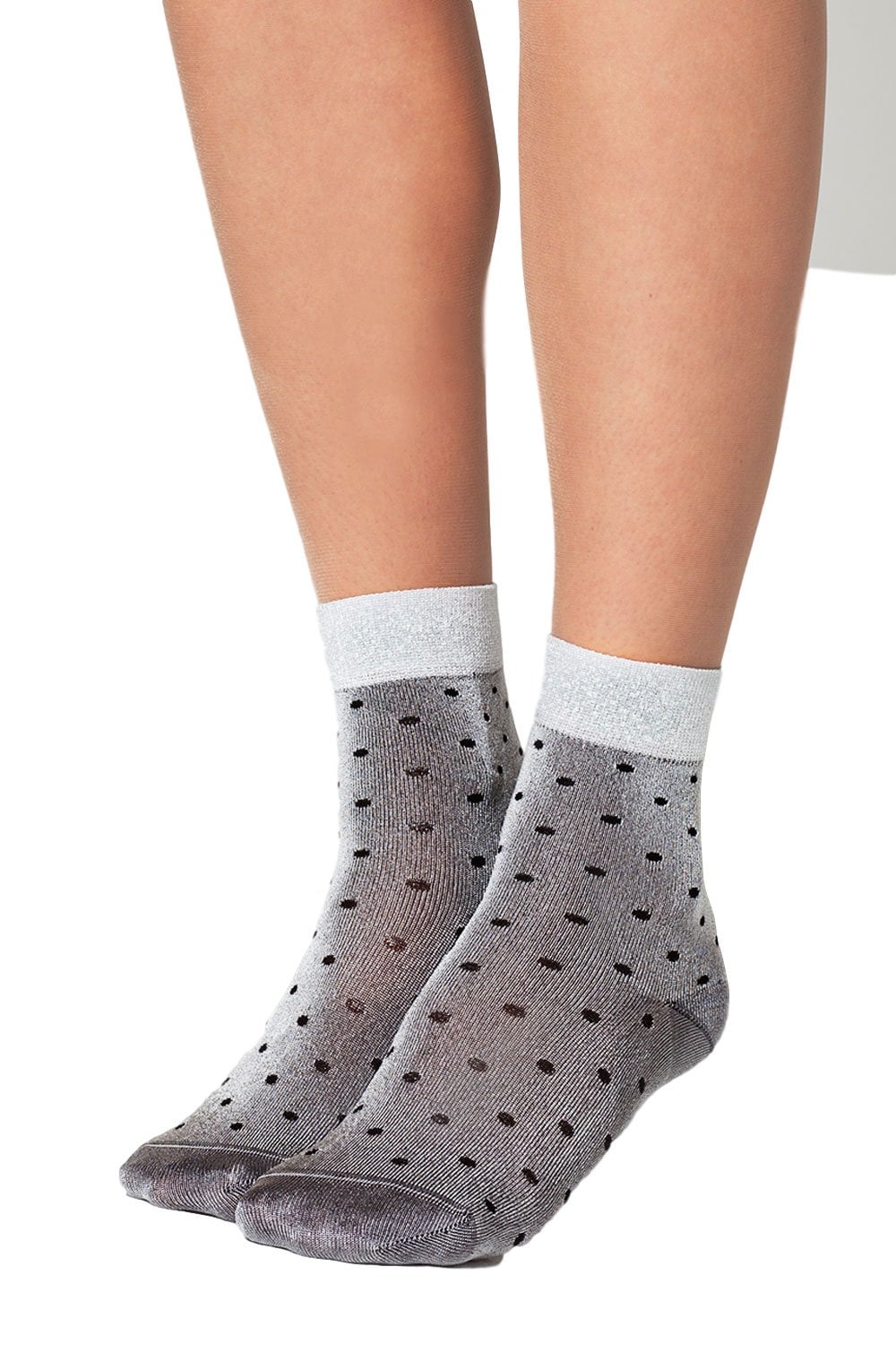 Grey socks with black polka dots worn by a model on a white background