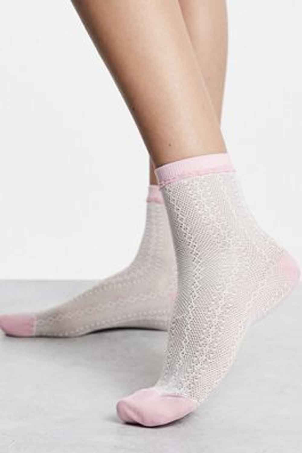 Pink/white socks worn by a model on a light gray background