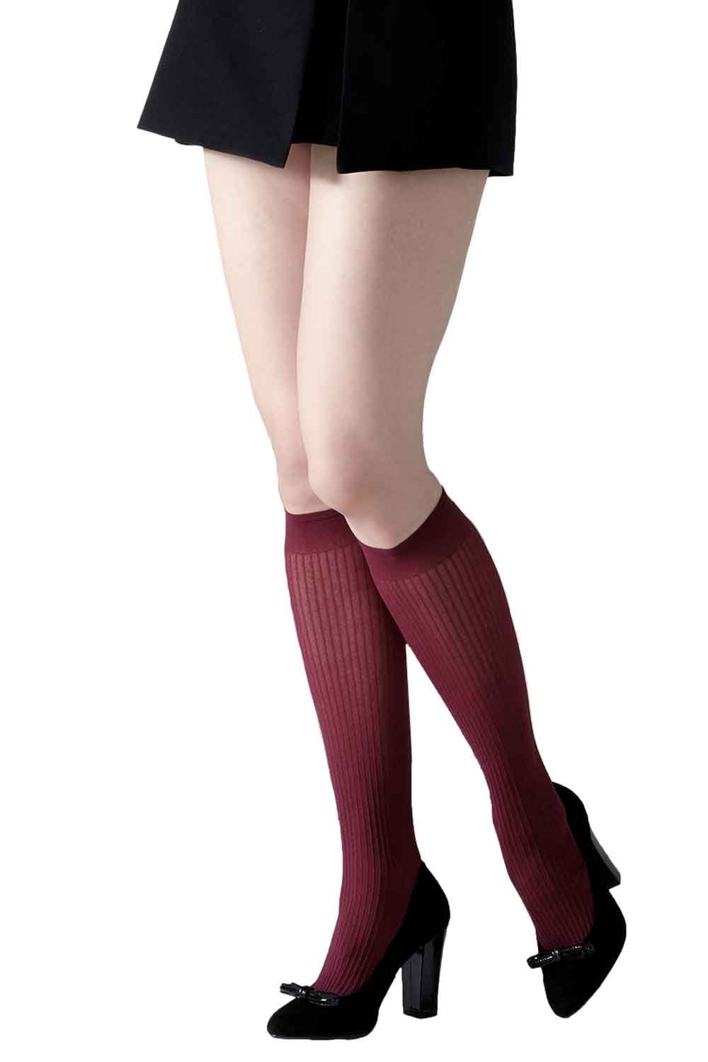 Model wearing plum coloured knee-high socks with black shoes on a white background