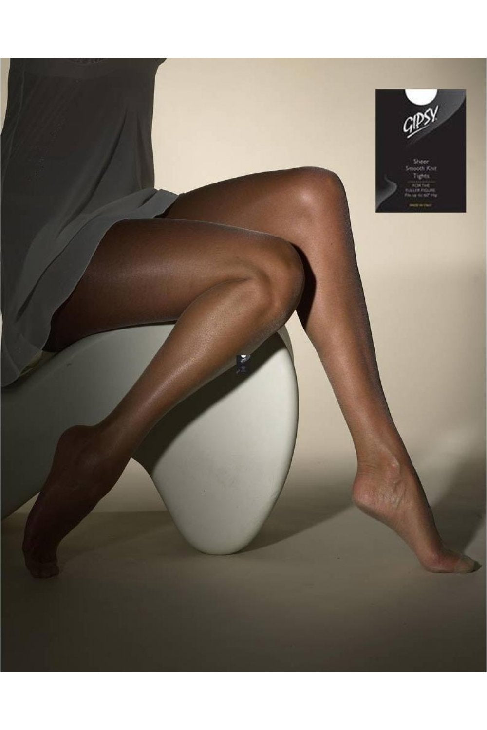 Model wearing sheer smooth knit tights sitting on a white chair with 'Gipsy' branding