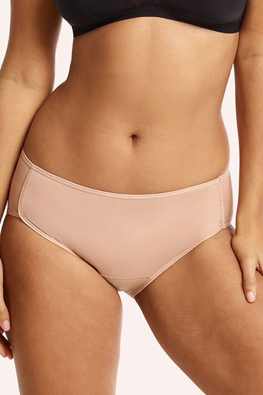 Person wearing beige period underwear with a neutral background