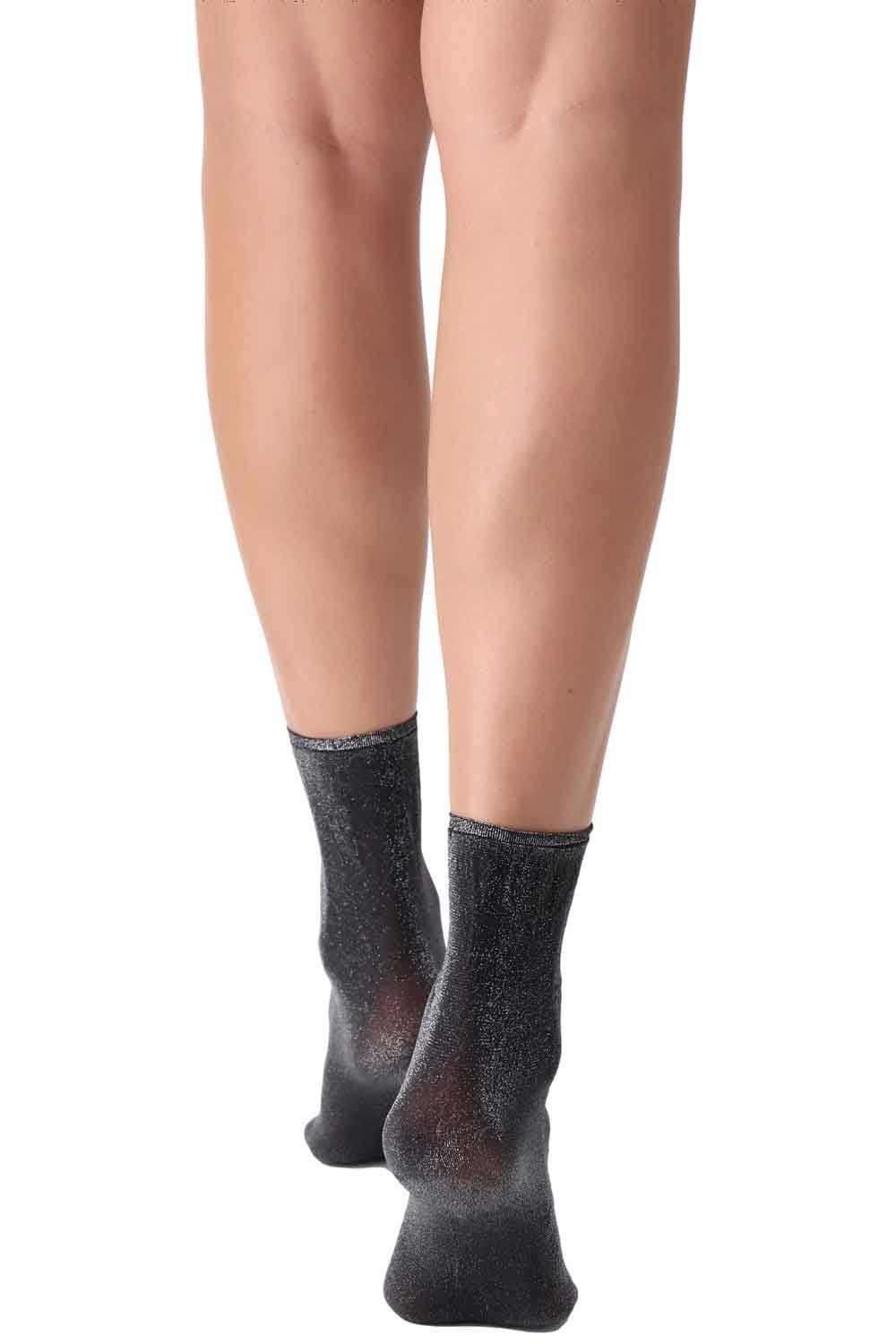 Silver sparkly socks worn by a person on a white background