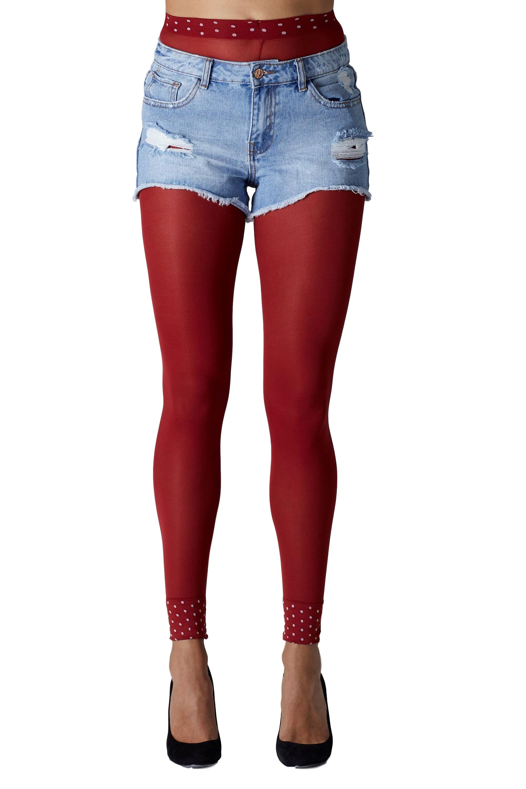Red footless tights with white polka dots cuff worn under denim shorts on a white background