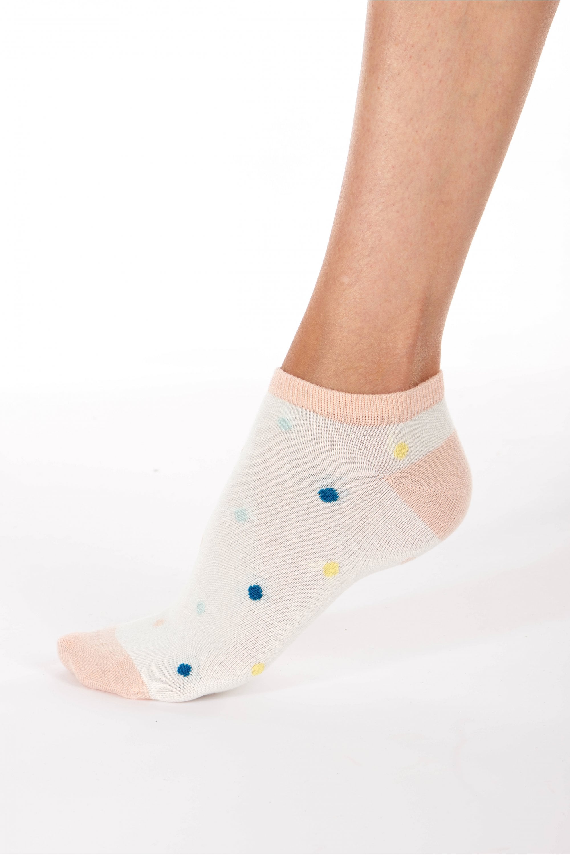 ankle sock with colorful polka dots worn by a person on a white background