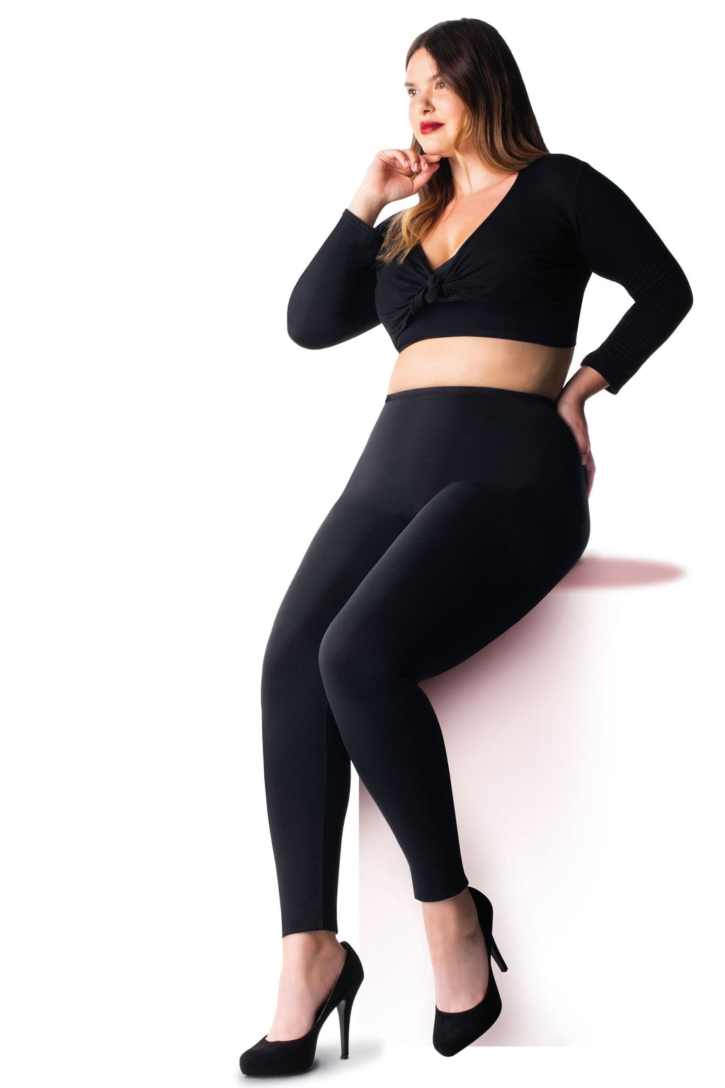 Woman wearing  black leggings  with a white background
