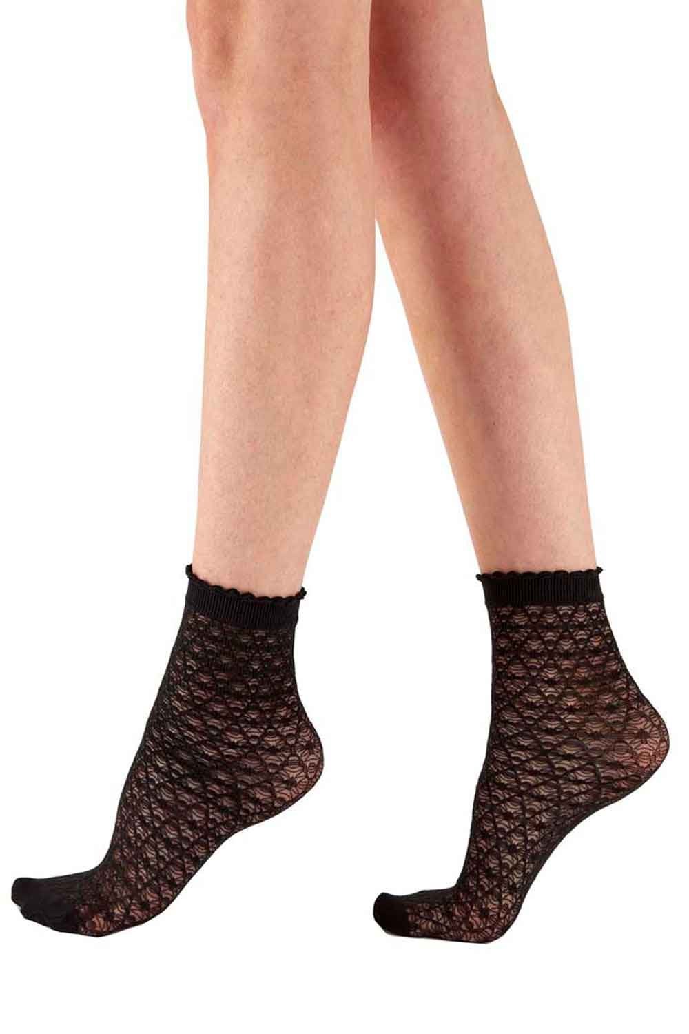 Black net socks worn by a person on a white background