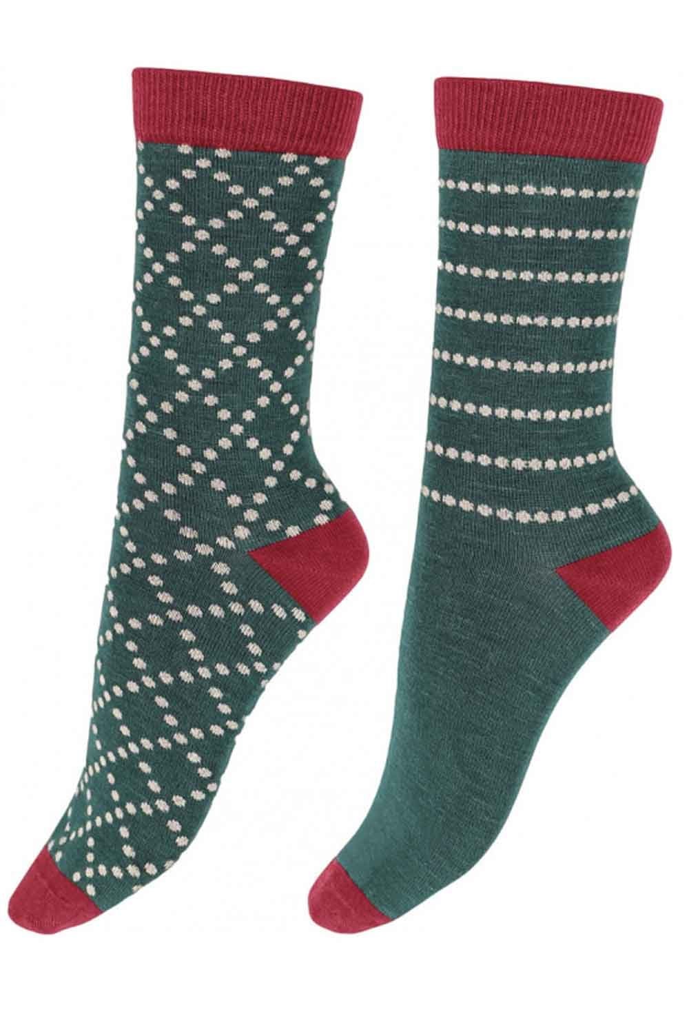 Pair of green socks with red accents and white patterns on a white background