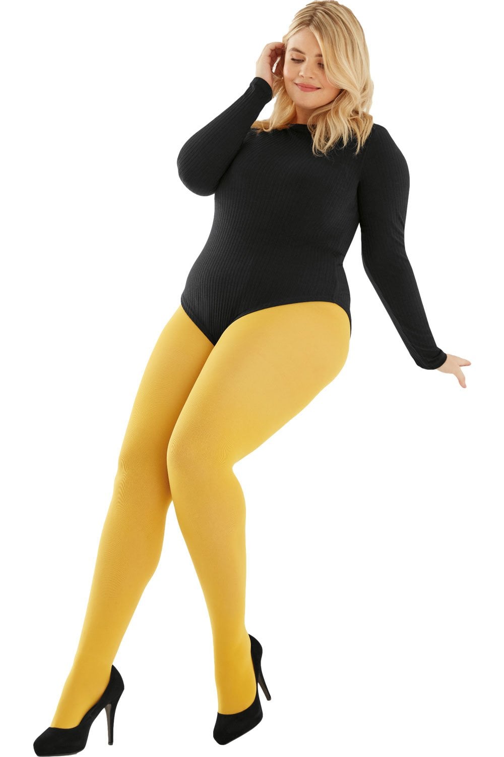 Woman wearing a black bodysuit and mustard  tights on a white background