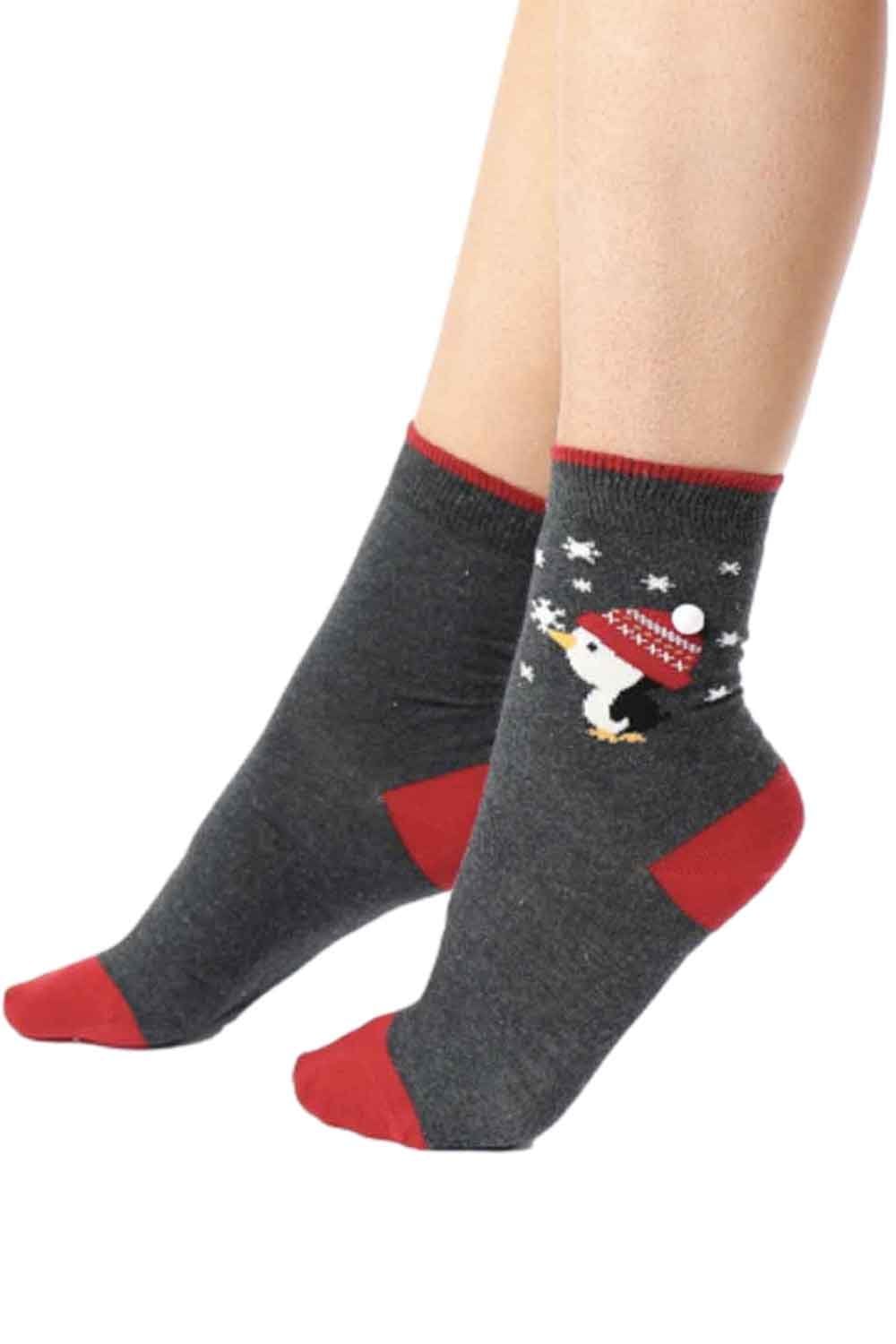 Gray socks with red accents  and penguin design worn by a person on a white background