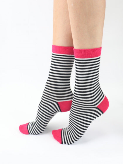 Black and white striped socks with pink accents worn by a person on a white background