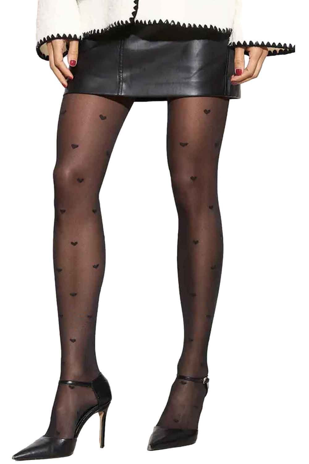 Black heart-patterned tights worn with a black leather skirt and black high heels on a white background.
