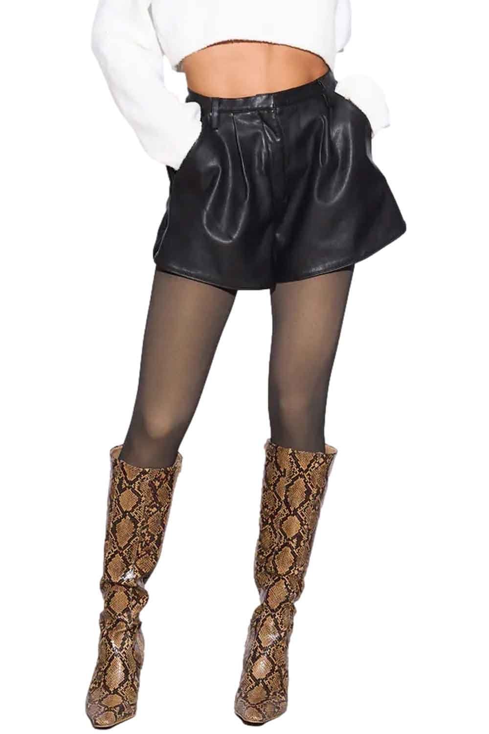Model wearing black leather shorts with fleece lined tights  and snake print boots on a white background