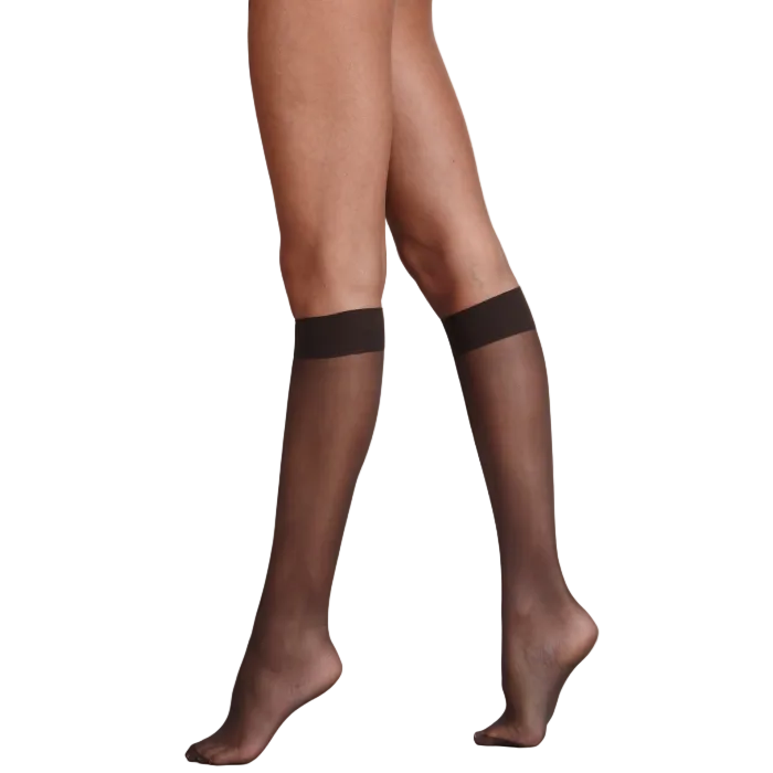 barely black sheer knee highs worn by a person on a plain background