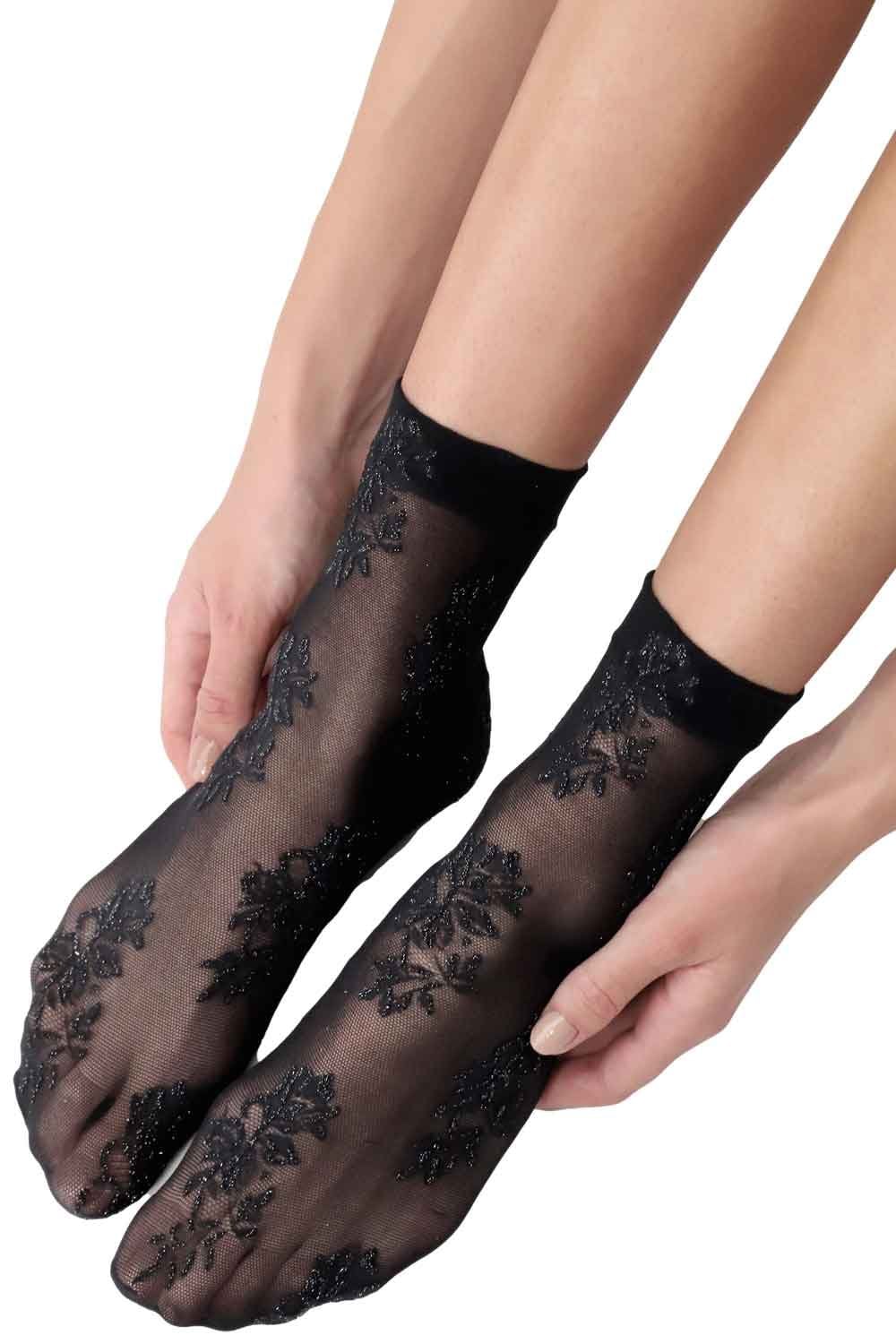Black lace socks worn by a person on a white background