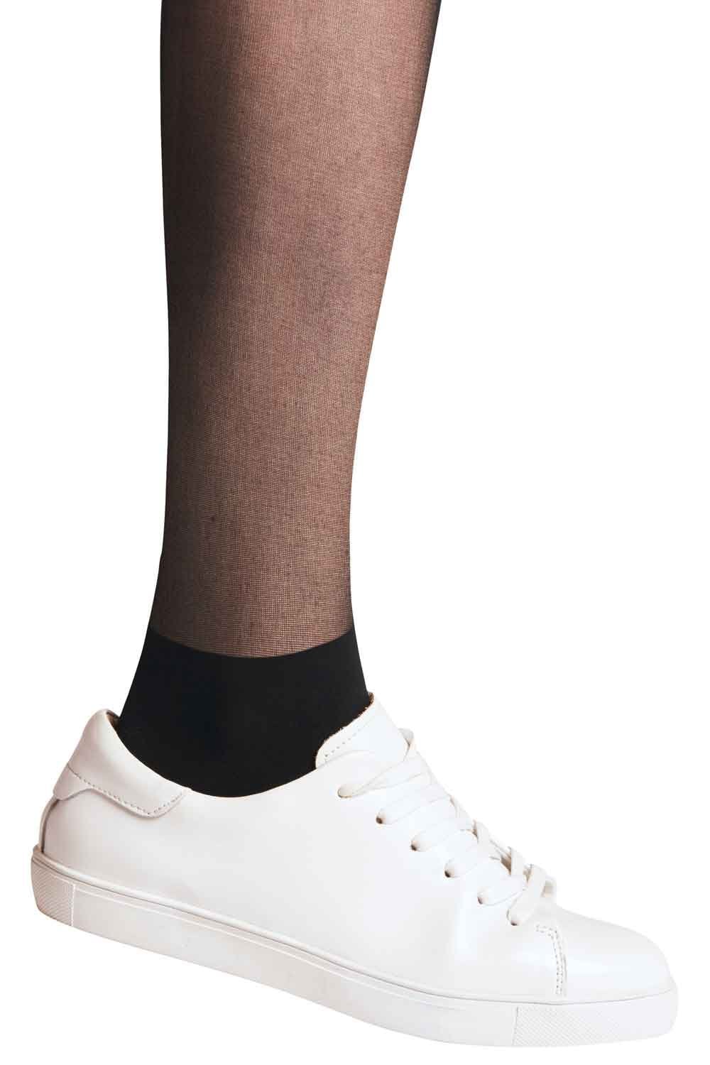 Person wearing black tights and white sneakers on a white background