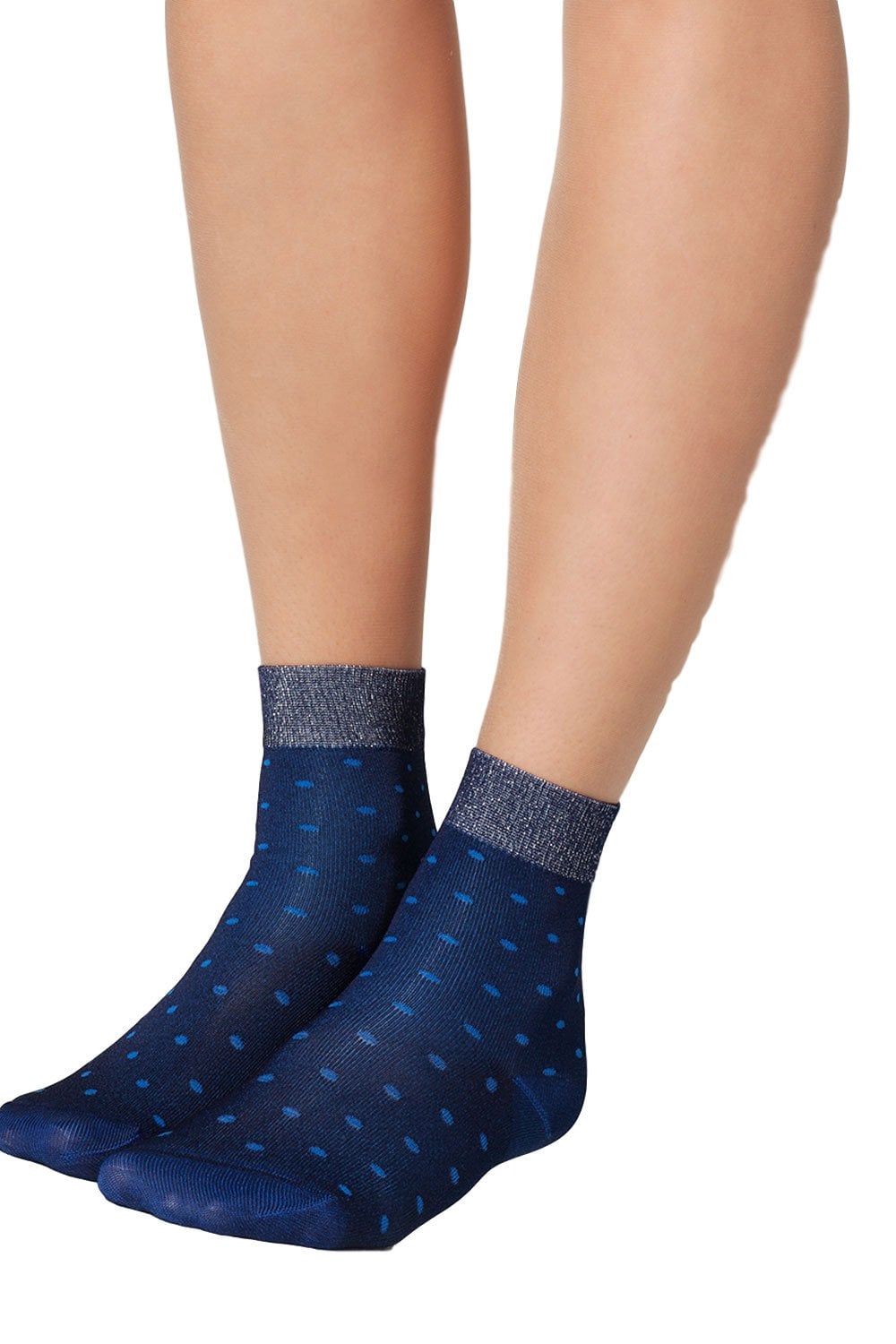 Navy blue socks with  polka dots worn by a model on a white background