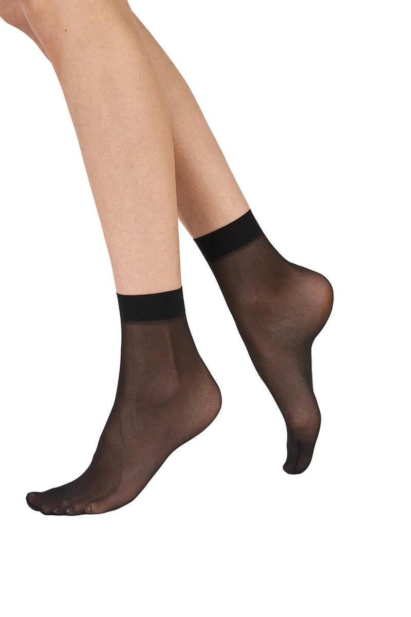 Black sheer socks worn by a person on a white background