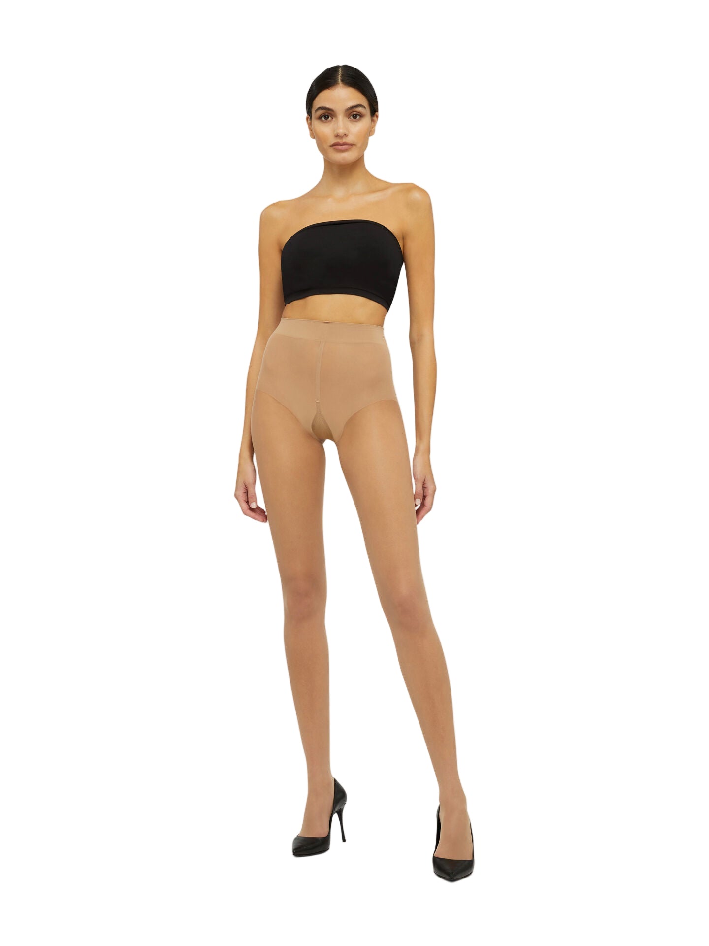 Woman wearing beige tights and a black top on a white backgrounde  