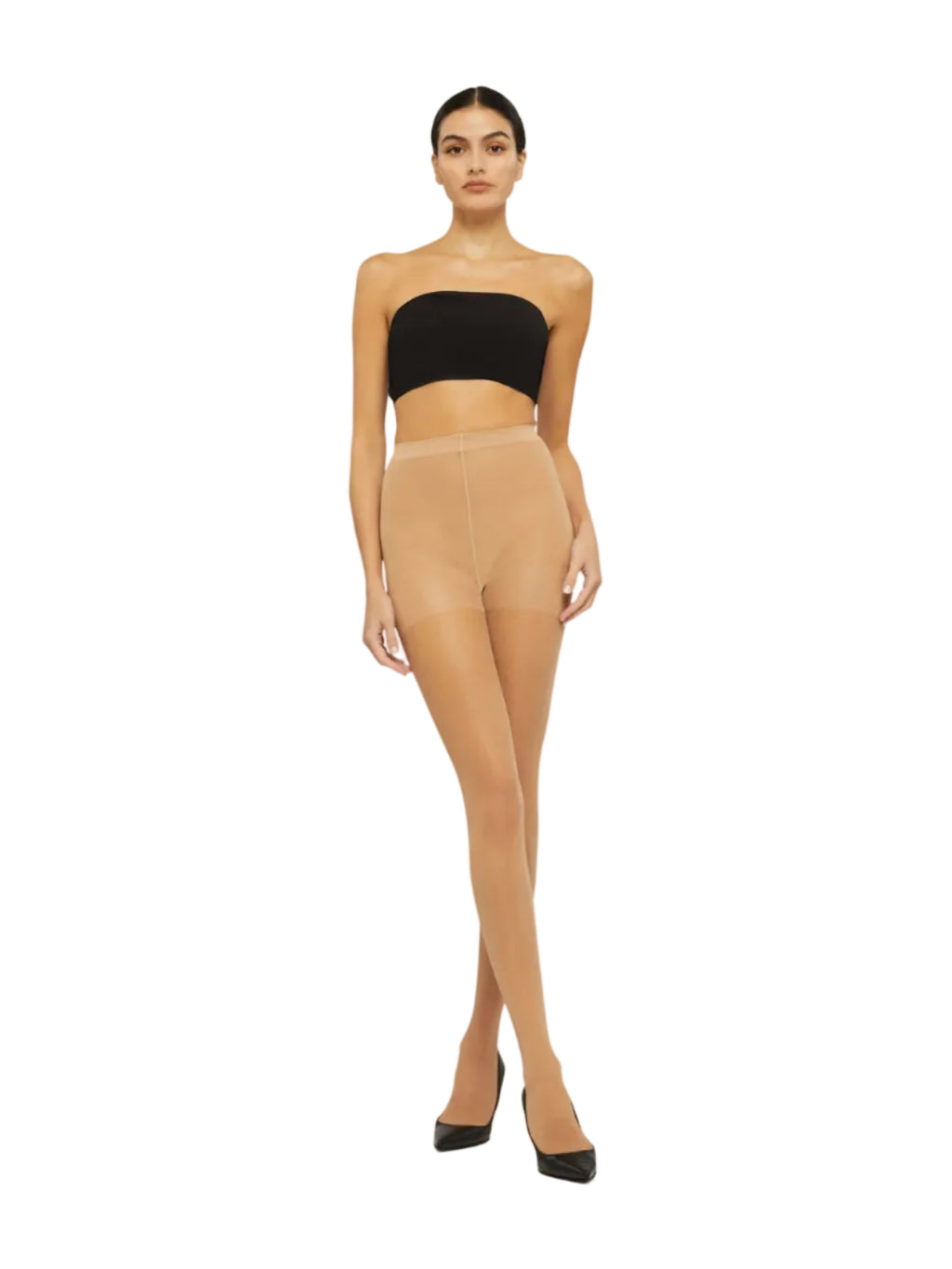 A model stands against a plain light background wearing sheer nude tights, a black strapless tube top, and black pointed heels.