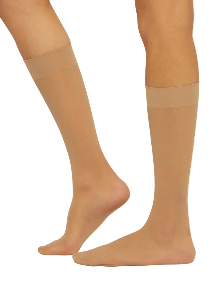 Beige knee-high socks worn by a person on a white background