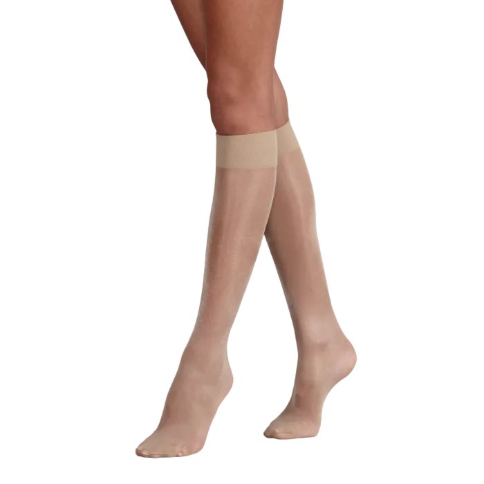 Beige sheer knee highs worn by a person on a white background