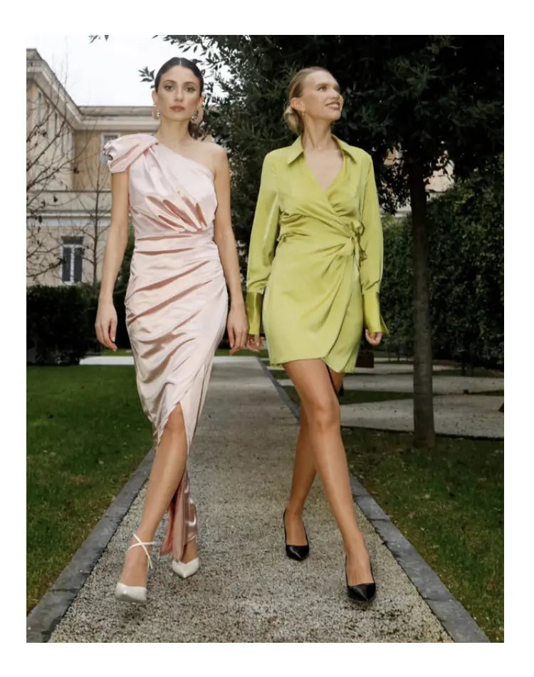 Two women walking outdoors, wearing tights, dresses and heels