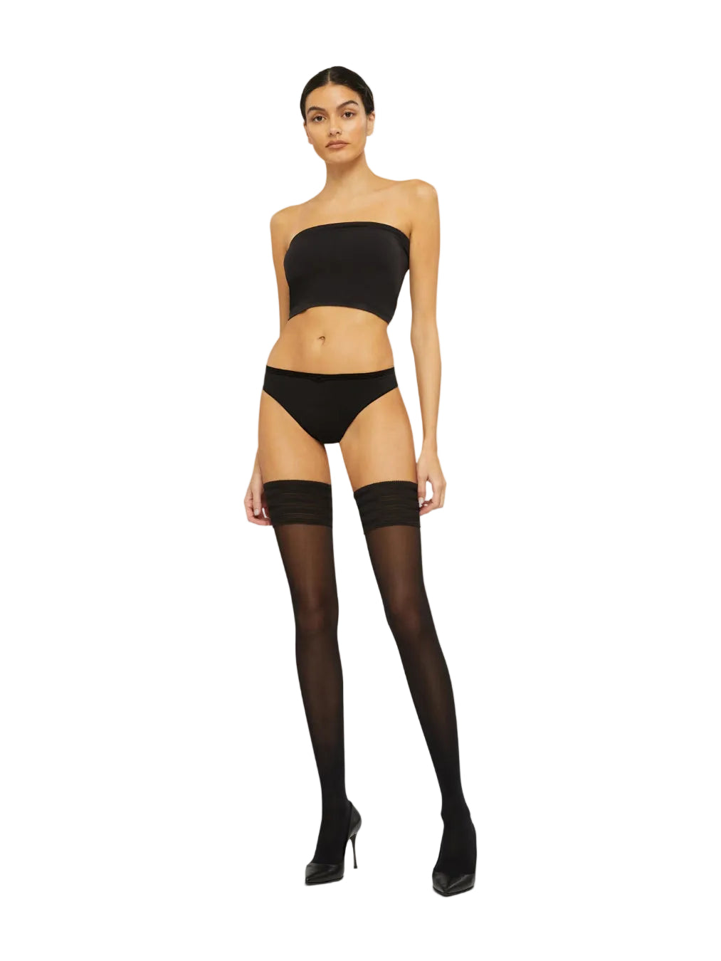 Woman wearing a black strapless top with black hold ups on a white background
